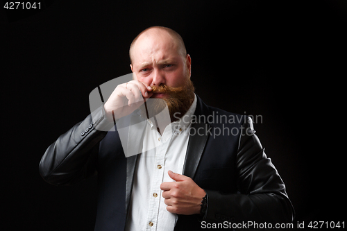 Image of Pleased man touches ginger mustaches