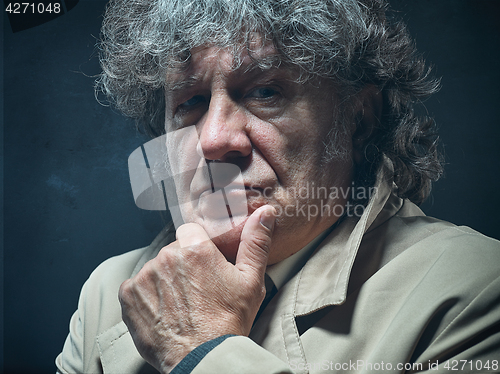 Image of The senior man as detective or boss of mafia on gray studio background