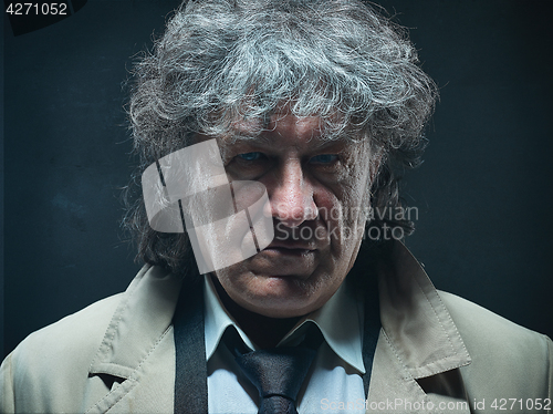 Image of The senior man as detective or boss of mafia on gray studio background