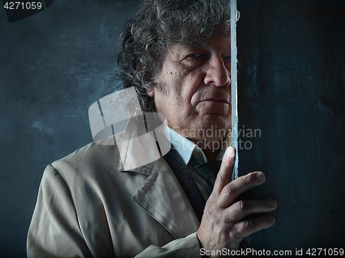 Image of The senior man as detective or boss of mafia on gray studio back