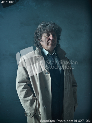 Image of The senior man as detective or boss of mafia on gray studio background