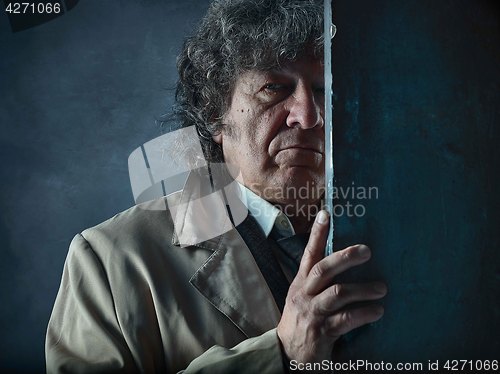 Image of The senior man as detective or boss of mafia on gray studio back