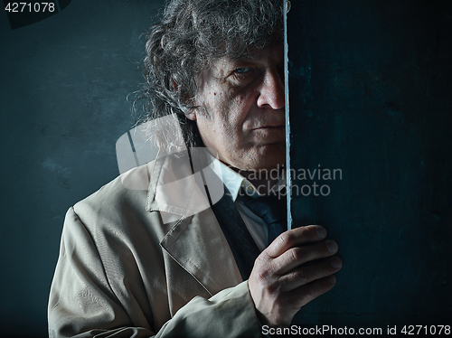 Image of The senior man as detective or boss of mafia on gray studio background