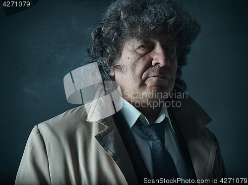 Image of The senior man as detective or boss of mafia on gray studio background