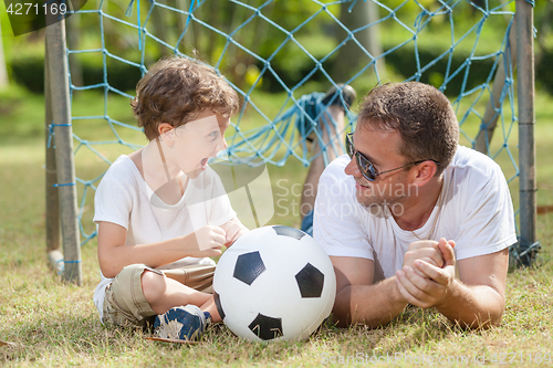 Image of Father and son playing in the park  at the day time.