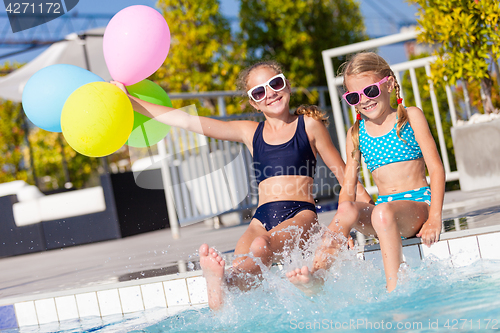 Image of Two happy children  playing on the swimming pool at the day time