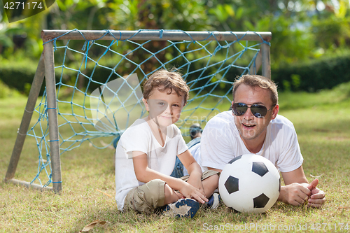 Image of Father and son playing in the park  at the day time.