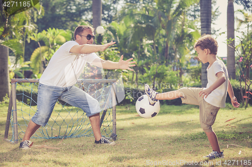 Image of Father and son playing in the park  at the day time.