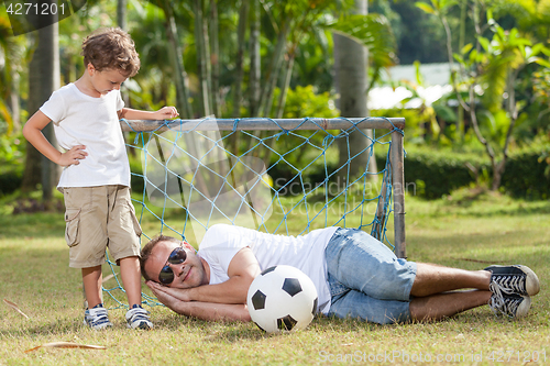 Image of Father and son playing in the park  at the day time.