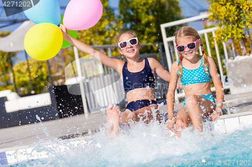 Image of Two happy children  playing on the swimming pool at the day time