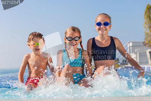 Image of happy children  playing on the swimming pool at the day time.