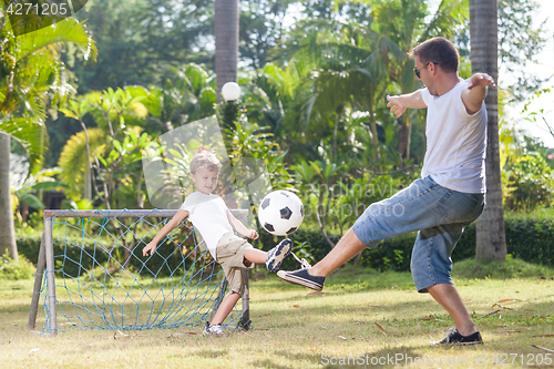 Image of Father and son playing in the park  at the day time.