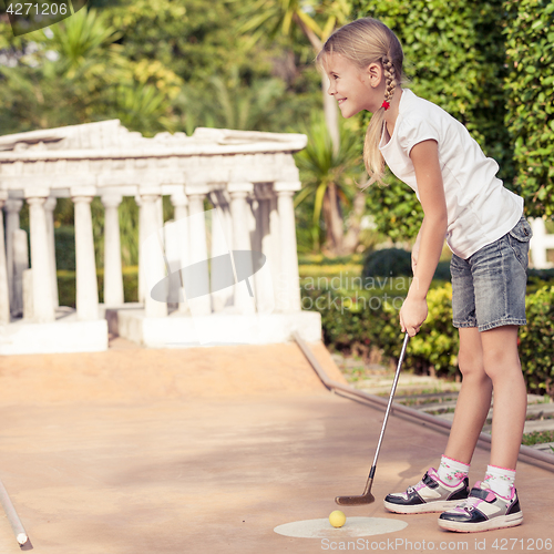 Image of Little girl swinging golf club