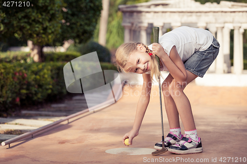 Image of Little girl swinging golf club