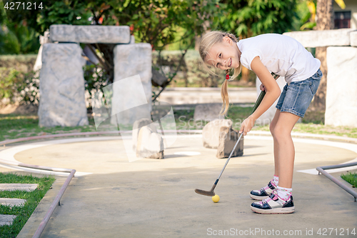 Image of Little girl swinging golf club