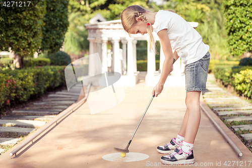 Image of Little girl swinging golf club