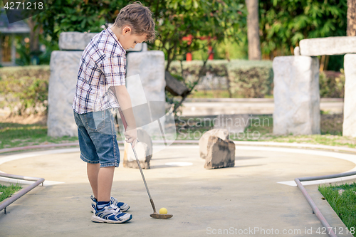 Image of Little boy swinging golf club