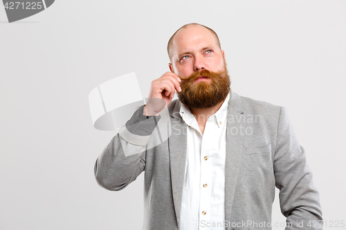 Image of Thoughtful man holds his mustache