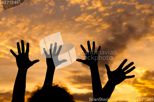 Image of silhouette of female hands during sunset. 