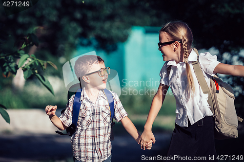 Image of Smiling young school children in a school uniform jumping on the