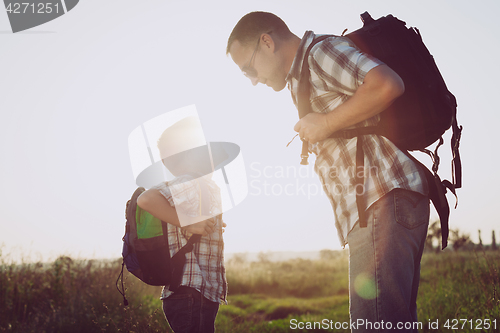 Image of Father and son playing in the park at the sunset time.