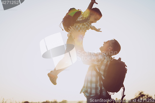 Image of Father and son playing in the park at the sunset time.