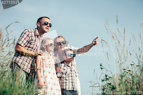 Image of Happy family walking on the field at the day time.