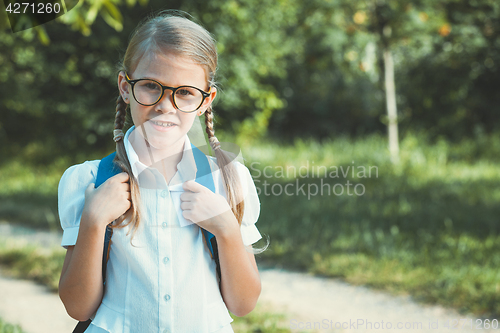 Image of Smiling young school child in a school uniform standing against 