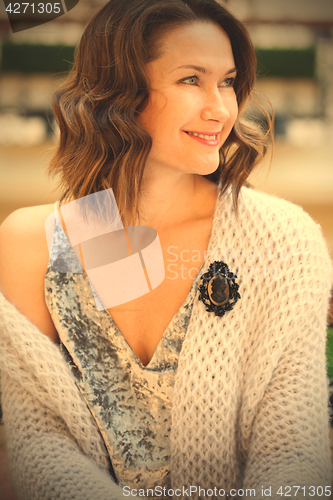 Image of smiling beautiful woman with a black cameo brooch