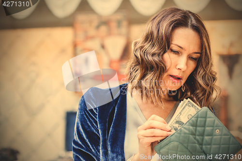 Image of woman counts the cash in her wallet