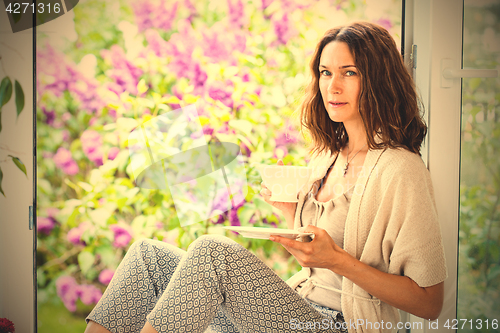 Image of beautiful middle-aged woman with a cup of hot drink