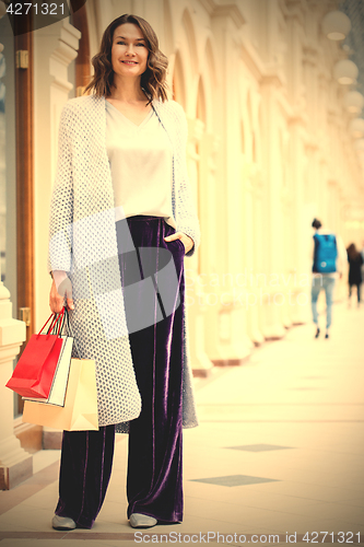 Image of beautiful woman with shopping bags in a big store