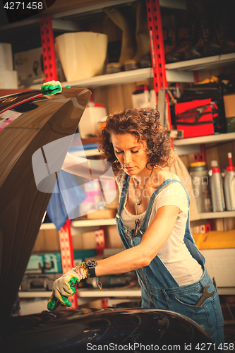 Image of Beautiful woman automechanic in blue overall 
