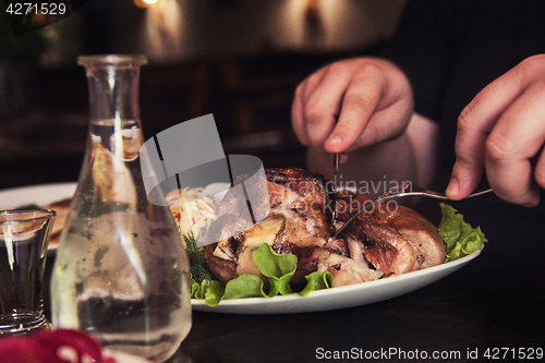 Image of Man eats tasty dish of pork shank