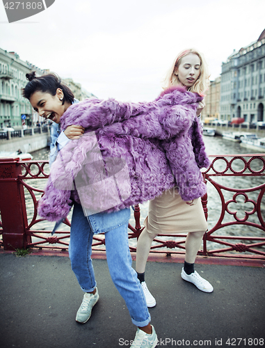 Image of Two teenage girls infront of university building smiling, having