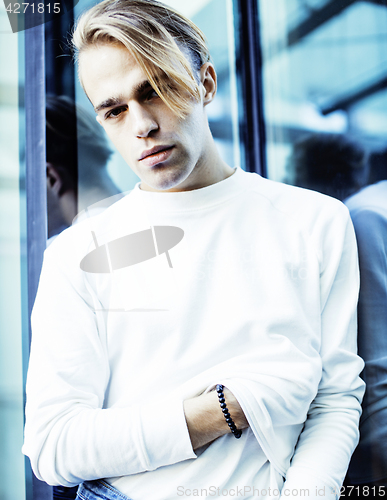 Image of young modern hipster guy at new building university blond fashio