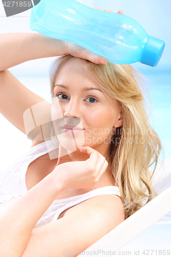 Image of Woman with bottle of water on beach 