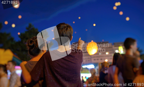 Image of Teens watching paper flying lanterns