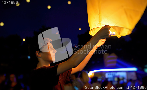 Image of Teen boy with paper flying lanterns