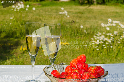 Image of Glasses with sparkling wine and a bowl with strawberries