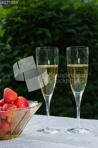 Image of Two glasses with sparkling wine and strawberries