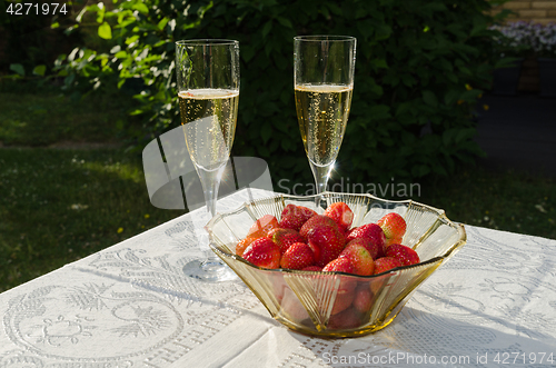 Image of Two glasses with champagne and strawberries