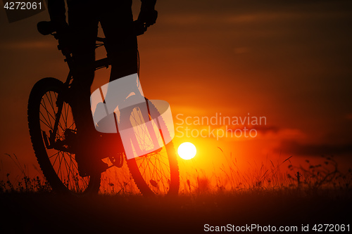 Image of Silhouette of a bike on sky background during sunset