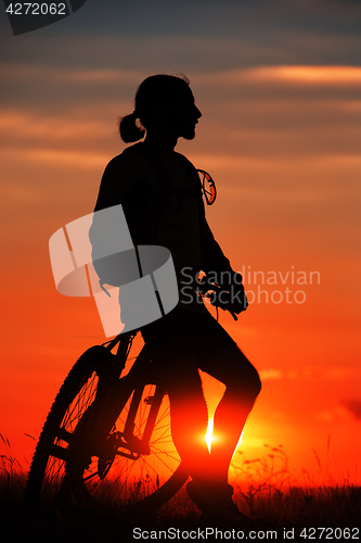 Image of Silhouette of a bike on sky background during sunset