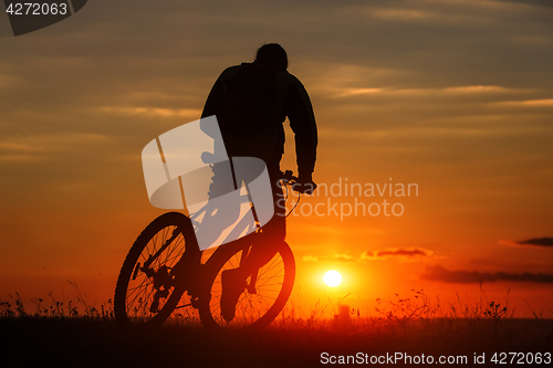 Image of Silhouette of a bike on sky background during sunset