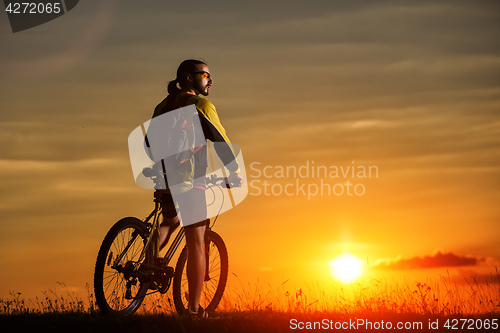 Image of Sporty Man Riding a Bicycle on the Country Road.