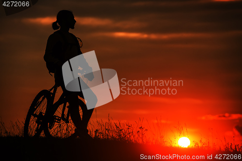 Image of Silhouette of a bike on sky background during sunset