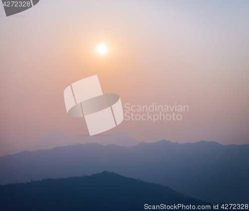 Image of Sun and haze with silhouetted hills