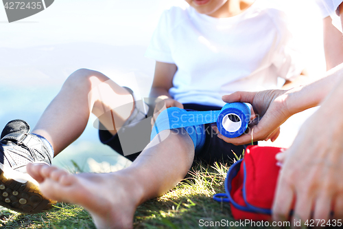 Image of Mother provides children knee elastic bandage.