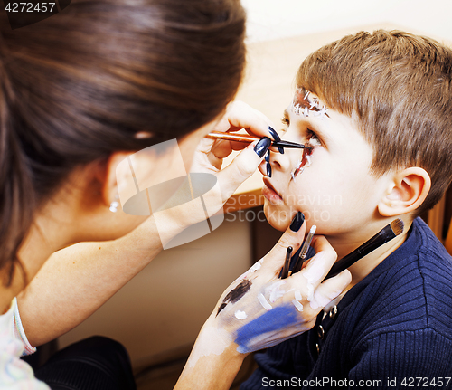 Image of little cute child making facepaint on birthday party, zombie Apo